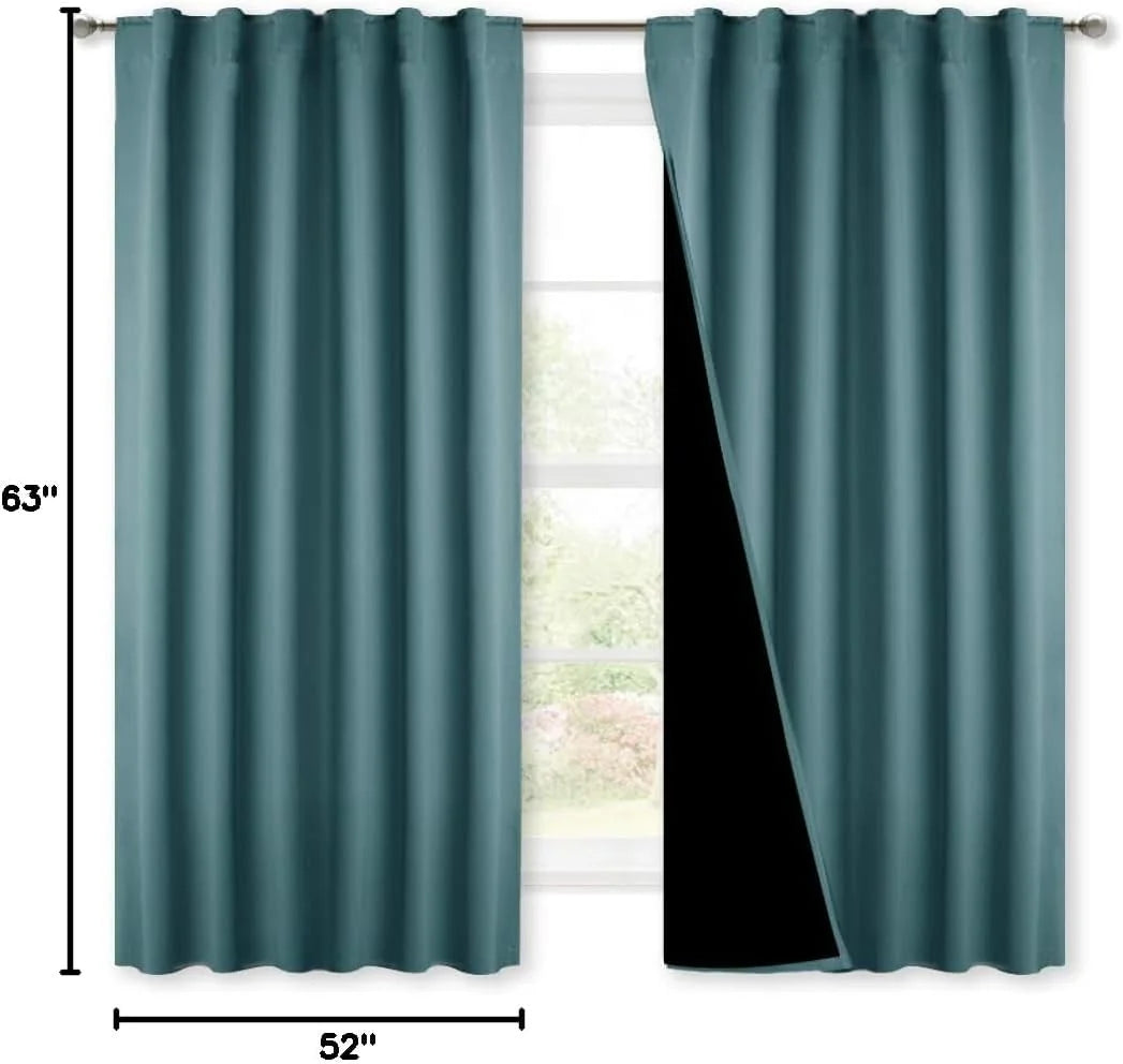 Teal blackout curtain panels on a rod with black lining shown over a window