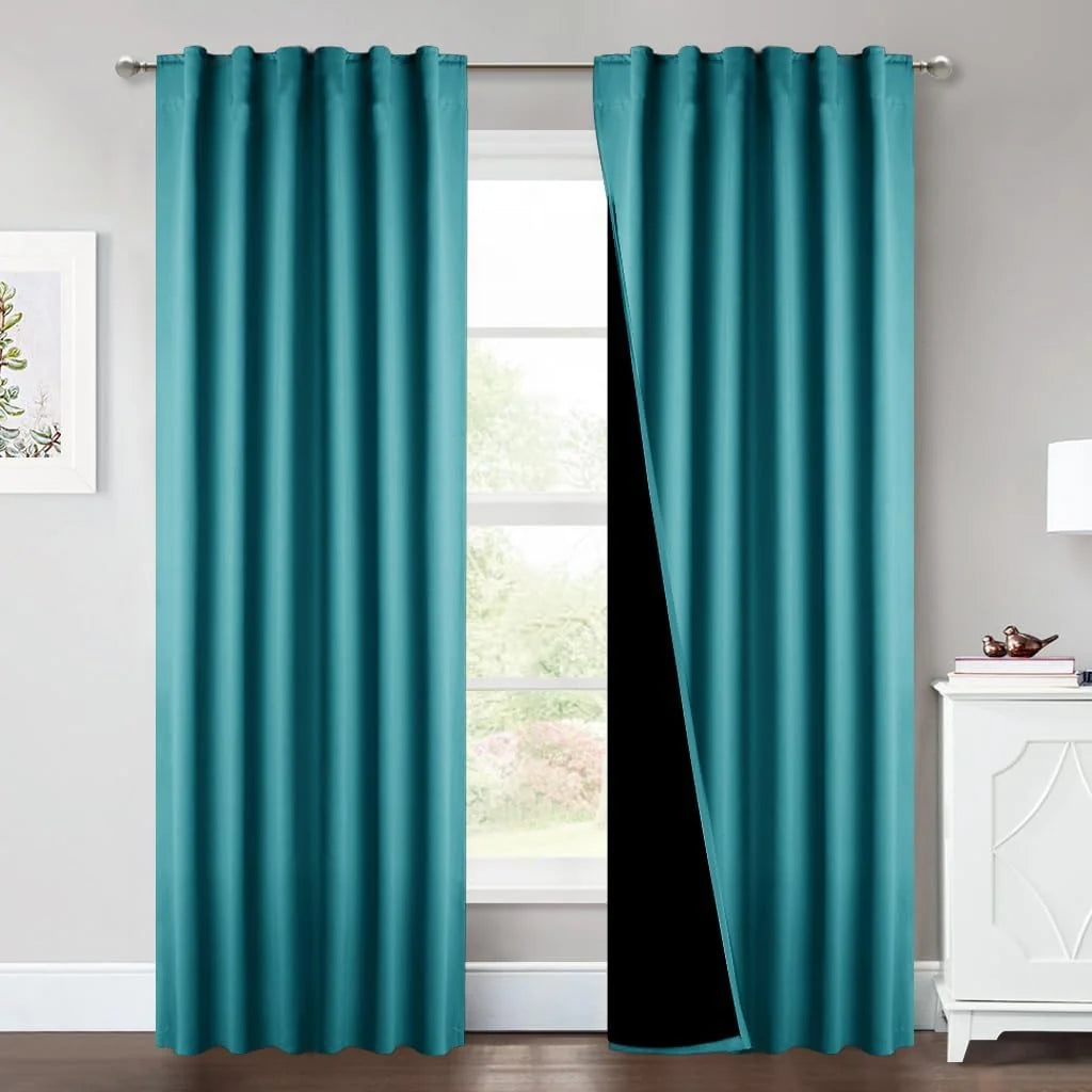 Teal blackout curtains on a silver rod in a bright modern room with black lining