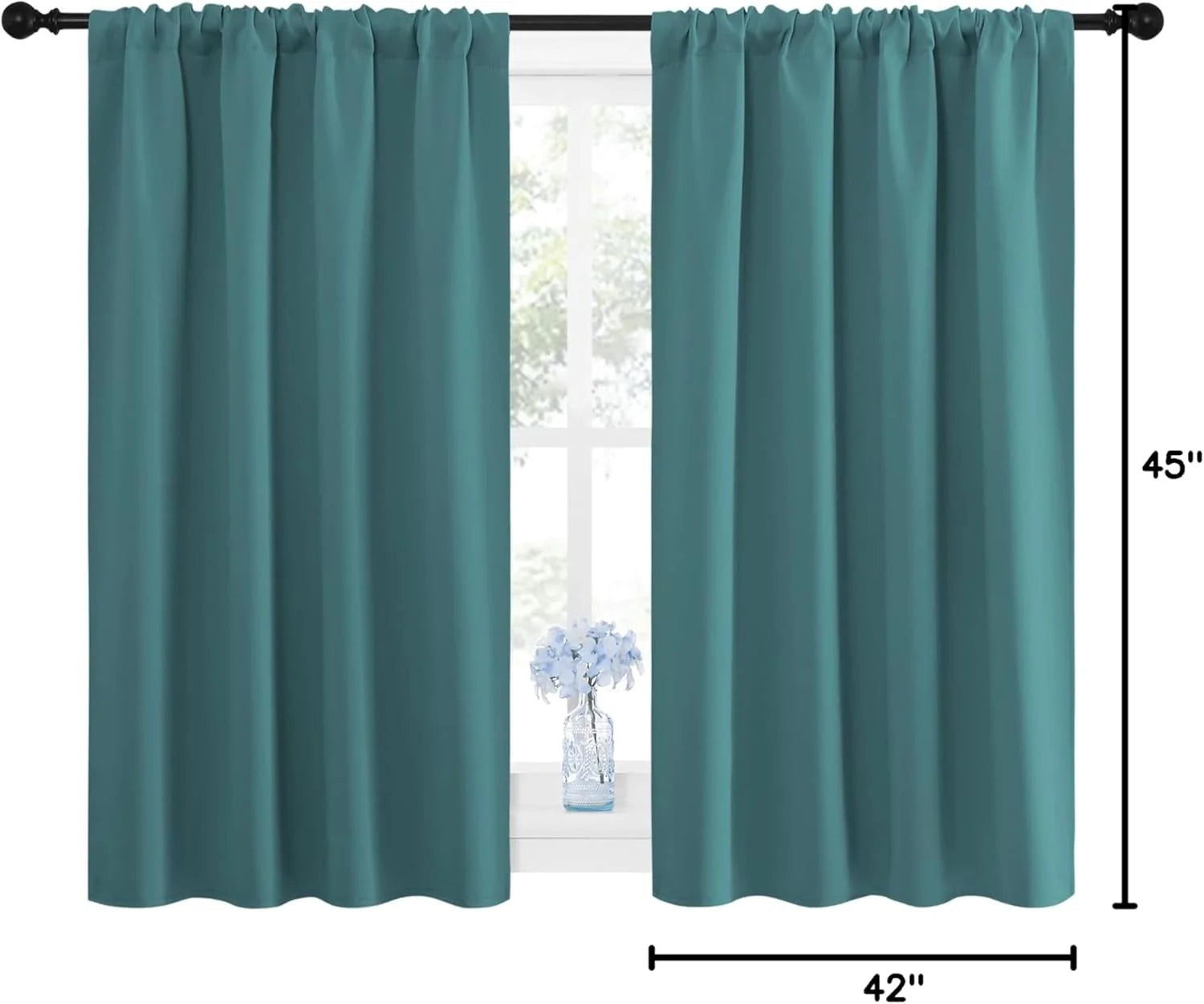Two teal rod pocket blackout curtains on a black rod over a window.