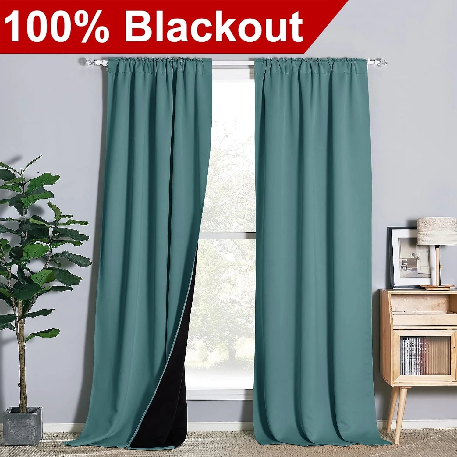 Teal blackout curtains with black lining on a white rod in a modern room