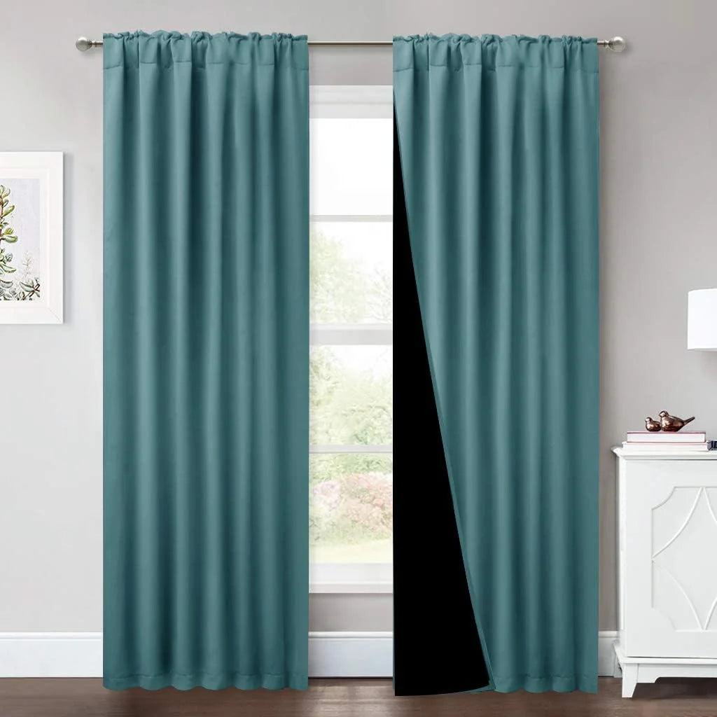 Teal blackout curtains with rod pocket top hanging in a bright modern room
