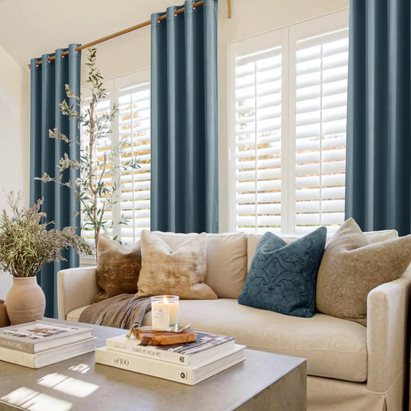 Teal blue grommet top curtains on golden rod in cozy living room with white window shutters.
