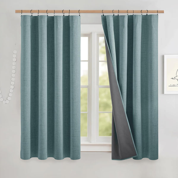 Teal blue linen textured blackout curtains with dark grey thermal lining, hanging on a natural wood rod.