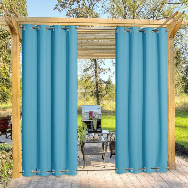 Pair of solid teal blue outdoor privacy curtains with silver grommet tops hanging from a wooden pergola.