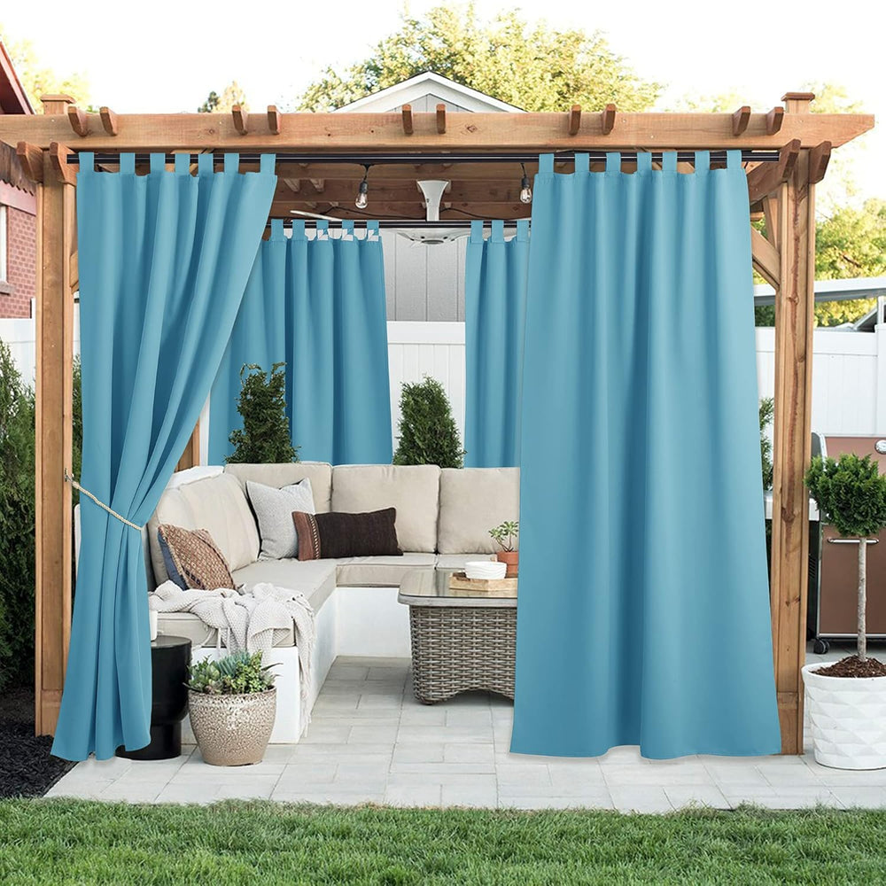 Vibrant teal tab top outdoor curtains on a wooden pergola, providing privacy to a patio.
