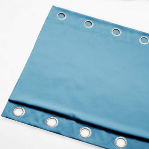 Close-up of a teal blue velvet curtain panel with silver grommet top rings