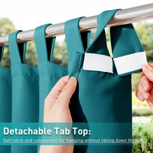 Close-up of a hand attaching a teal curtain with a detachable hook-and-loop tab top to a silver rod.