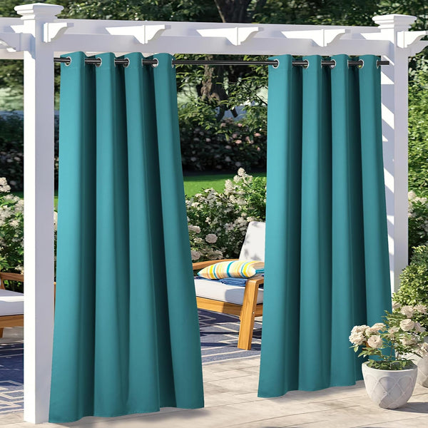 Teal outdoor grommet top curtains hanging from a white pergola in a sunny garden patio setting.