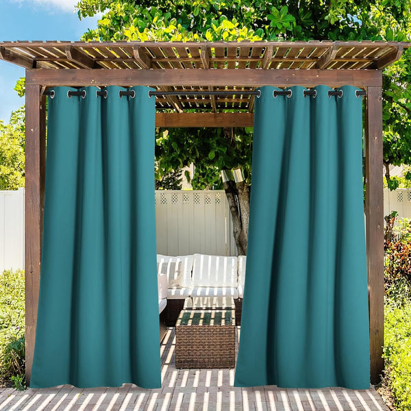 Teal outdoor privacy curtains with grommet tops hanging from a wooden pergola over a patio seating area.