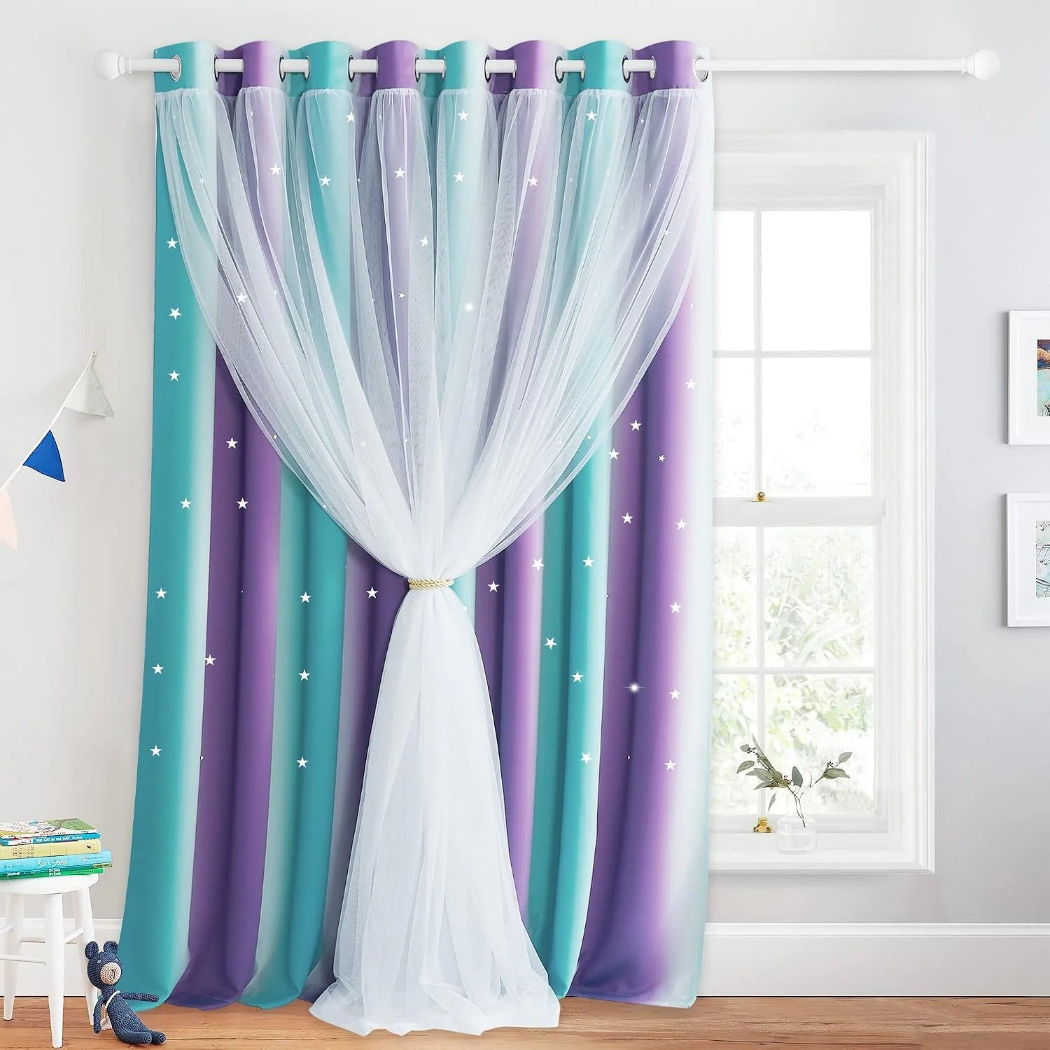 Teal and purple star print kids curtains with sheer white overlay on a bedroom window