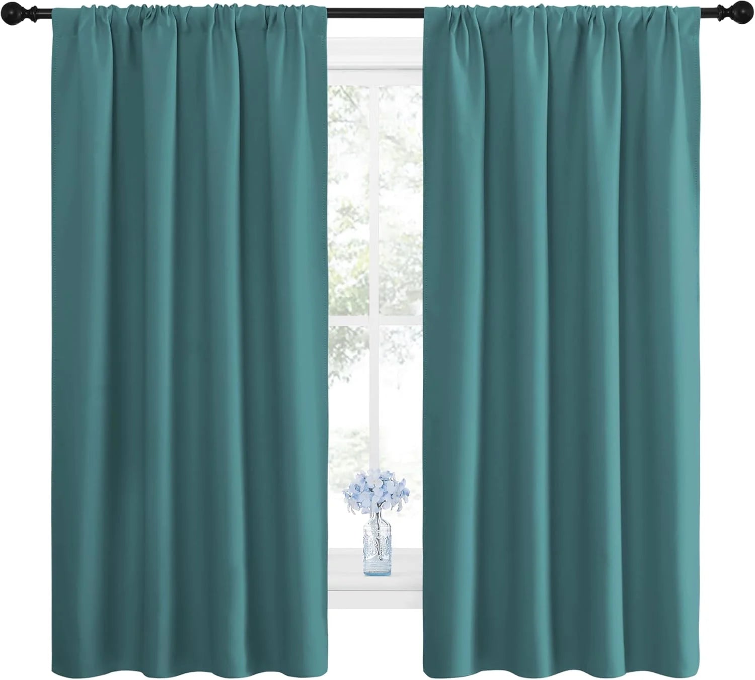 Pair of teal rod pocket curtains hanging on a dark rod, framing a bright window with a small vase of blue flowers.