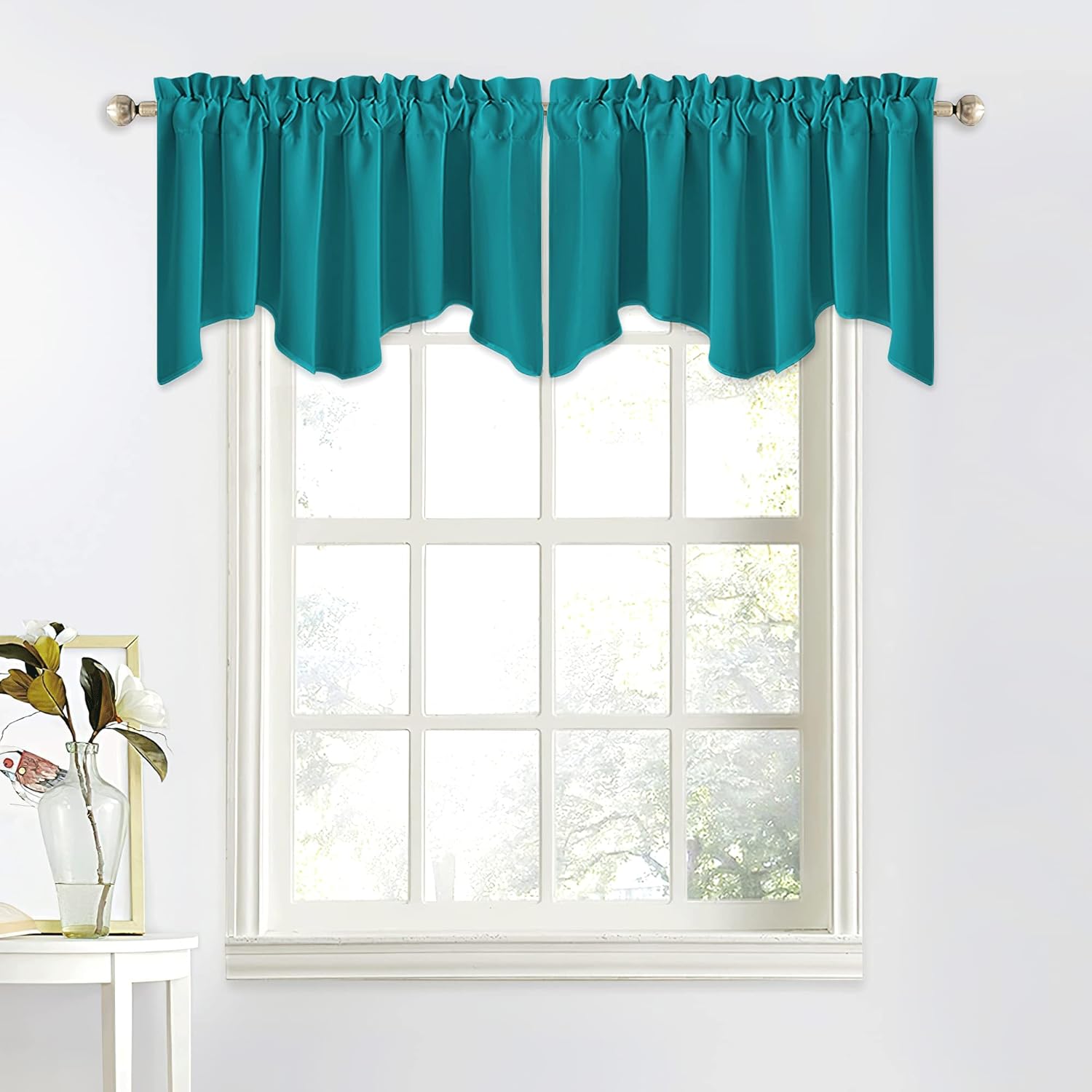 Teal scalloped rod pocket valance with ruffled top hanging on a silver rod over a white window.