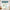 Teal blue fabric valance with scalloped hem and rod pocket hanging over a kitchen window.