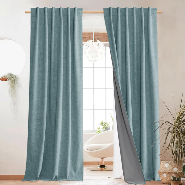 Teal textured blackout curtains with dark gray lining on a wooden rod. Set in a bright modern room.