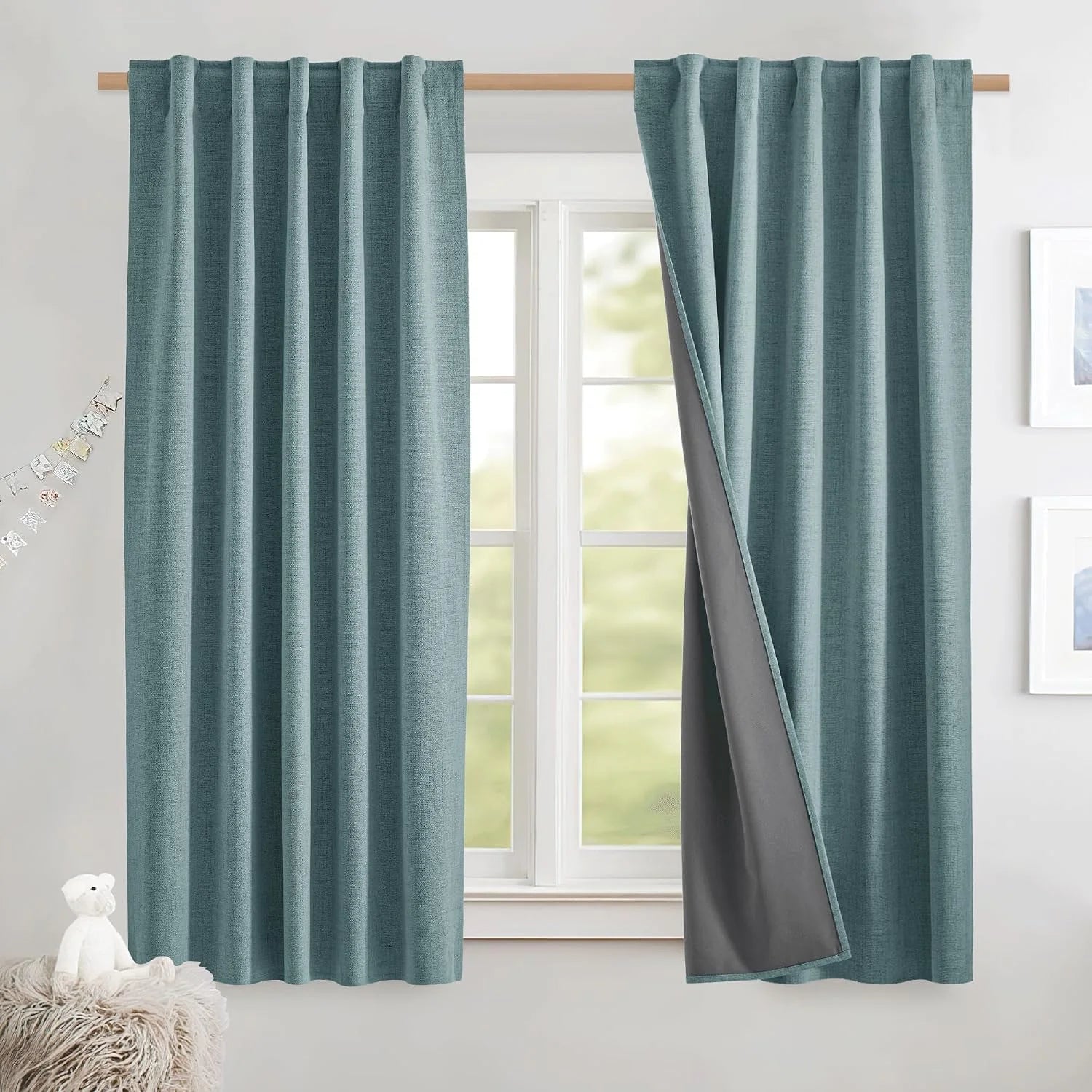 Teal textured blackout curtains with rod pocket top hanging over a bright window