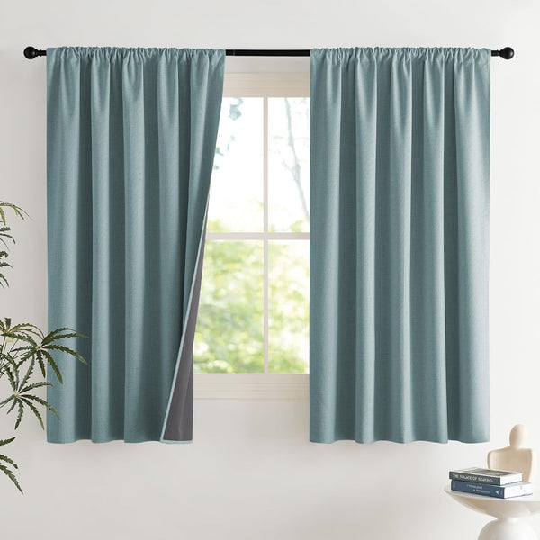 Teal textured rod pocket blackout curtains on a black rod, one panel open showing dark gray lining.