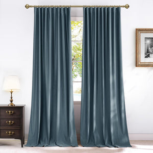 Floor-length teal velvet pinch pleat curtains on a brass rod, framing a bright window.