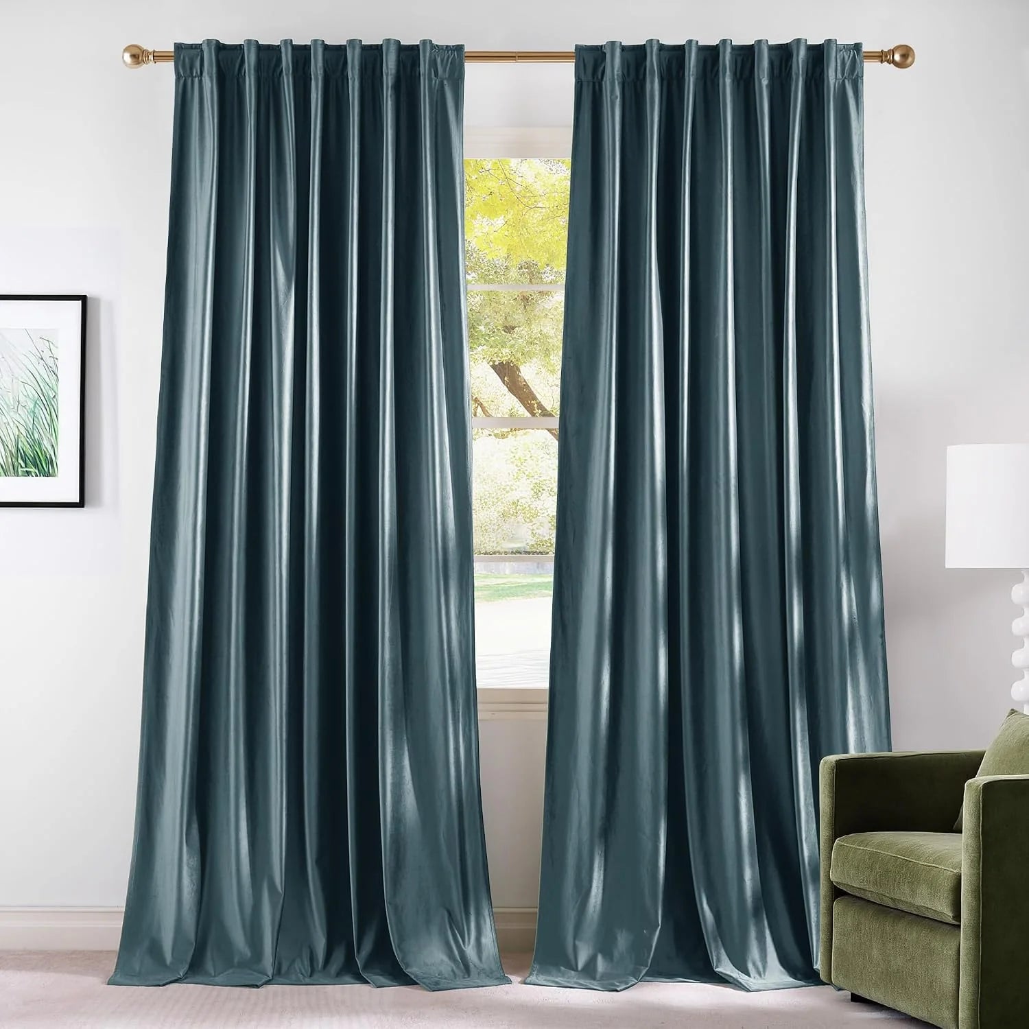 Teal velvet rod pocket curtains hanging on a brass rod in a bright modern room