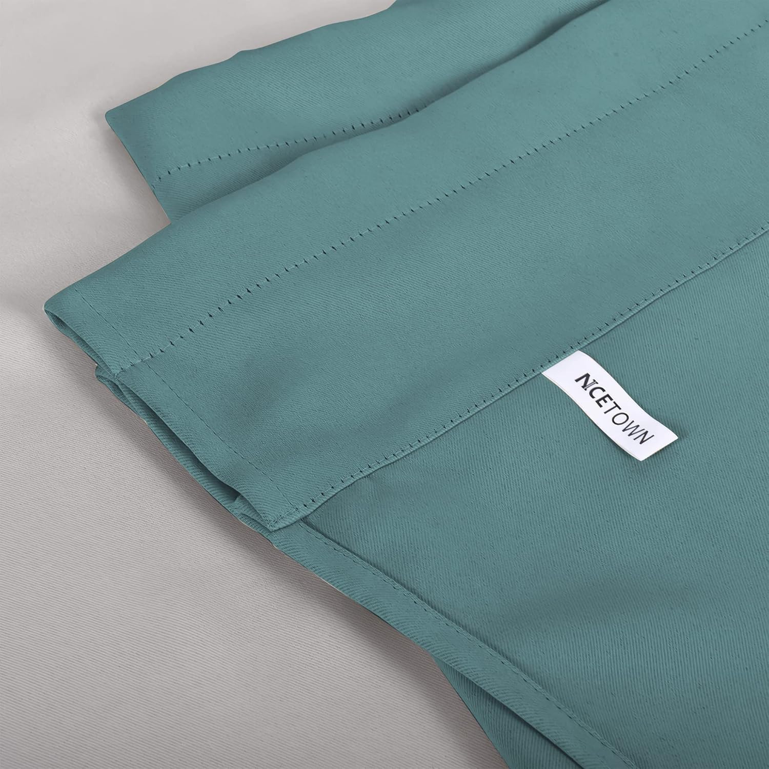 Teal woven fabric curtain panel, showing a stitched header and white NICETOWN brand label.