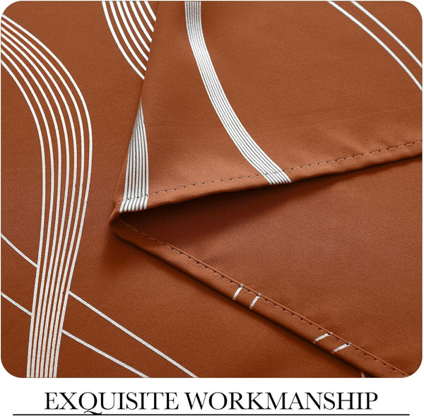 Terracotta fabric with white art deco geometric lines. Close-up shows neat stitching detail on the hem.