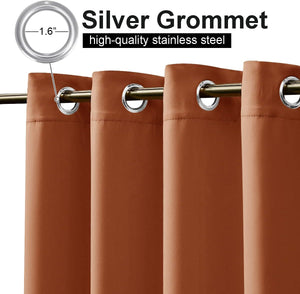 Close-up of terracotta-colored blackout curtains with silver grommet tops, hanging on a golden rod.