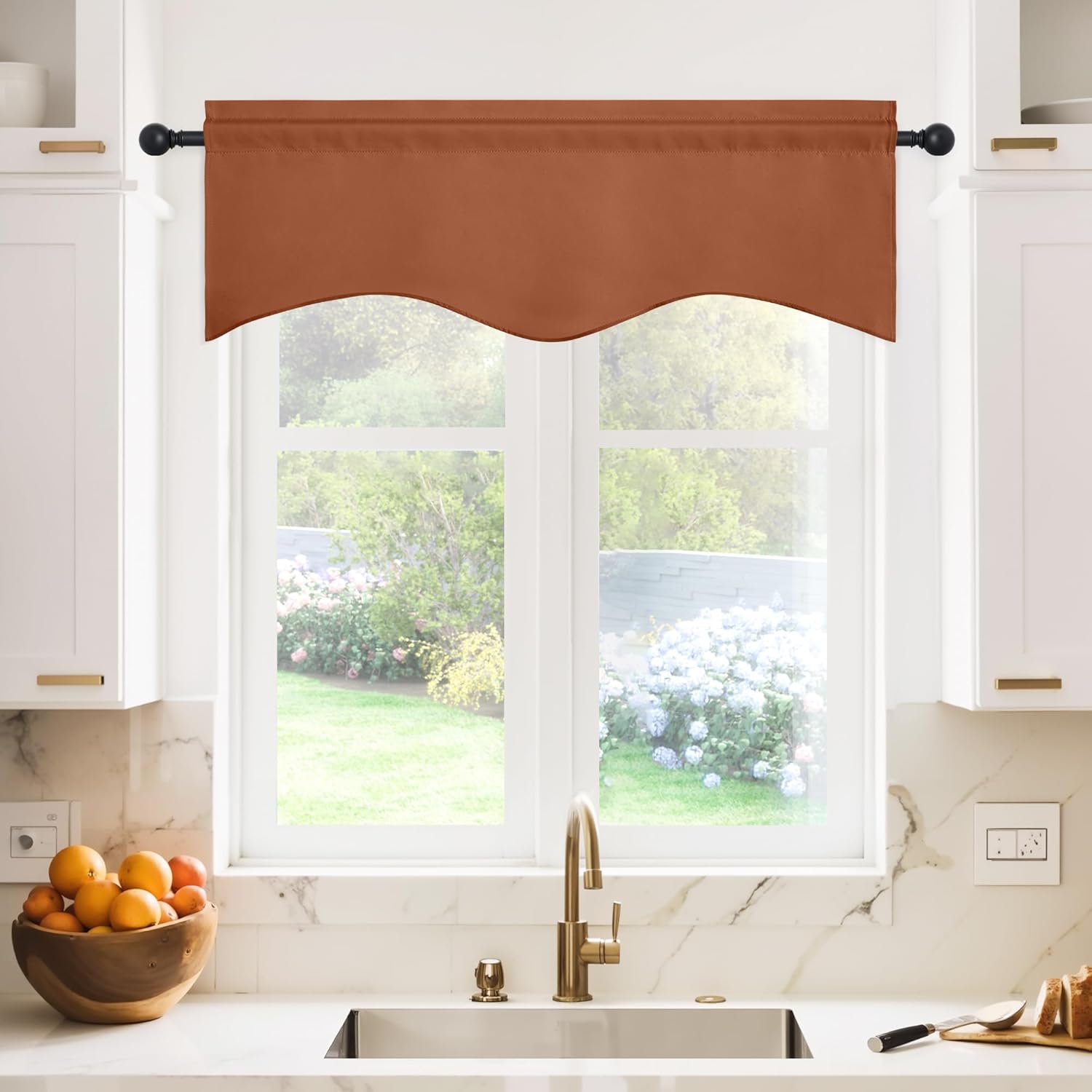 Terracotta scalloped valance with rod pocket hanging on a black rod in a bright kitchen.
