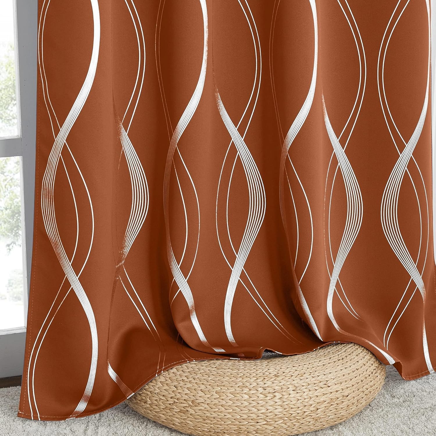 Terracotta curtain with a shimmering white vertical wavy line pattern, draped gracefully near a window.