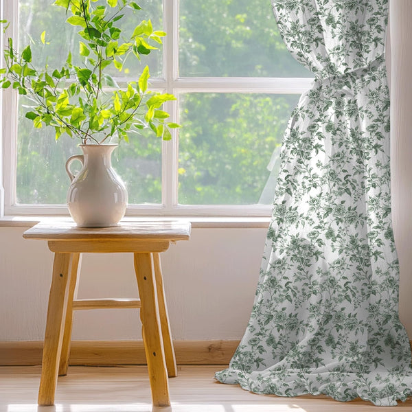 White curtain with a dark green vintage rose and floral pattern. Tied back elegantly at a window, draping to the floor.