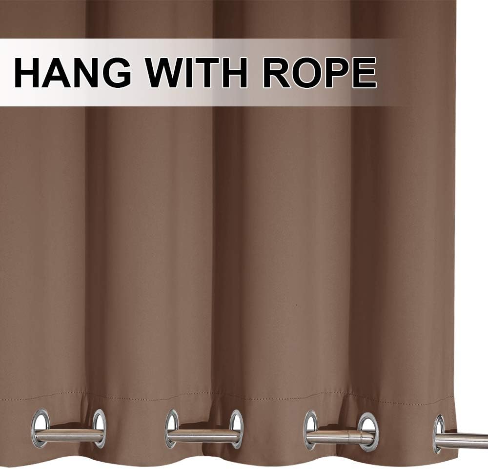 Close-up of a warm brown smooth fabric curtain with silver metal grommets, hanging from a rod.
