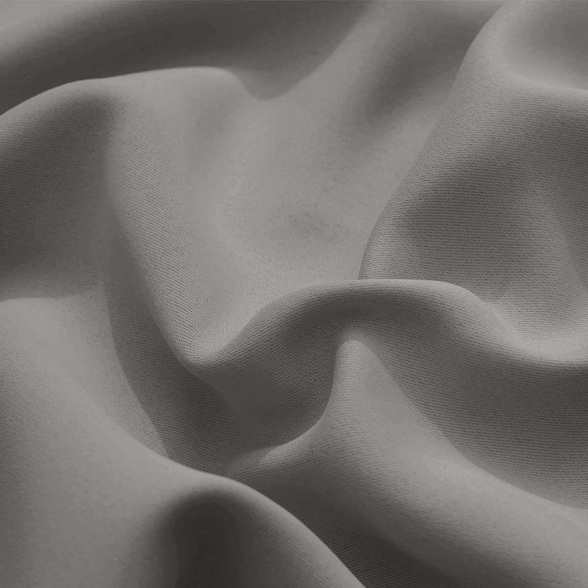 Close-up of warm grey woven fabric showing its subtle texture and soft, natural drapes.