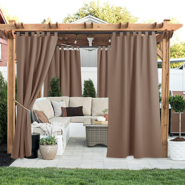 Weatherproof brown outdoor tab top curtains hanging from a pergola, creating a private patio seating area.