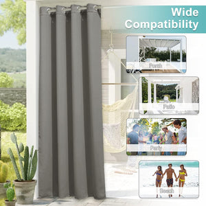 Single gray weatherproof outdoor curtain panel with silver grommets hangs on a sunny patio, offering privacy.