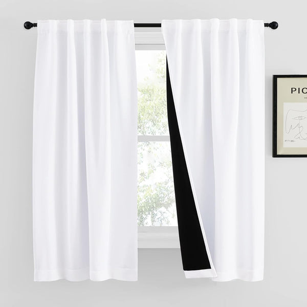 White blackout curtains with black lining, back tab header, hanging on black rod, partially open.