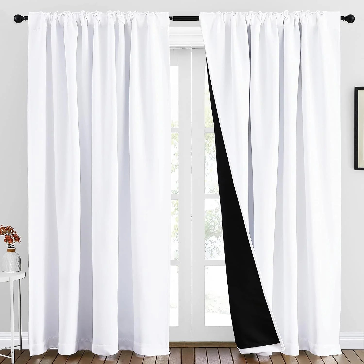 White rod pocket blackout curtains with black lining over a bright window