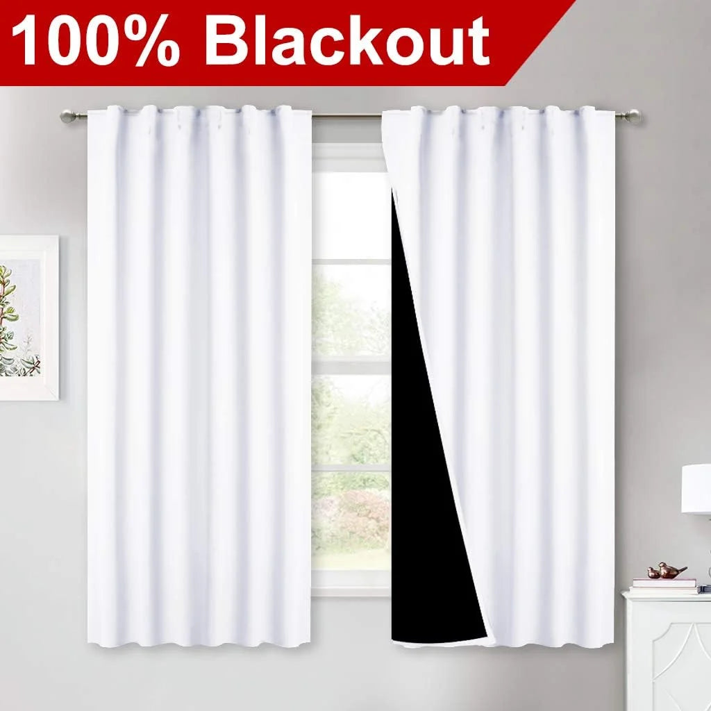 White 100% blackout curtains with black lining on a rod in a bright modern room