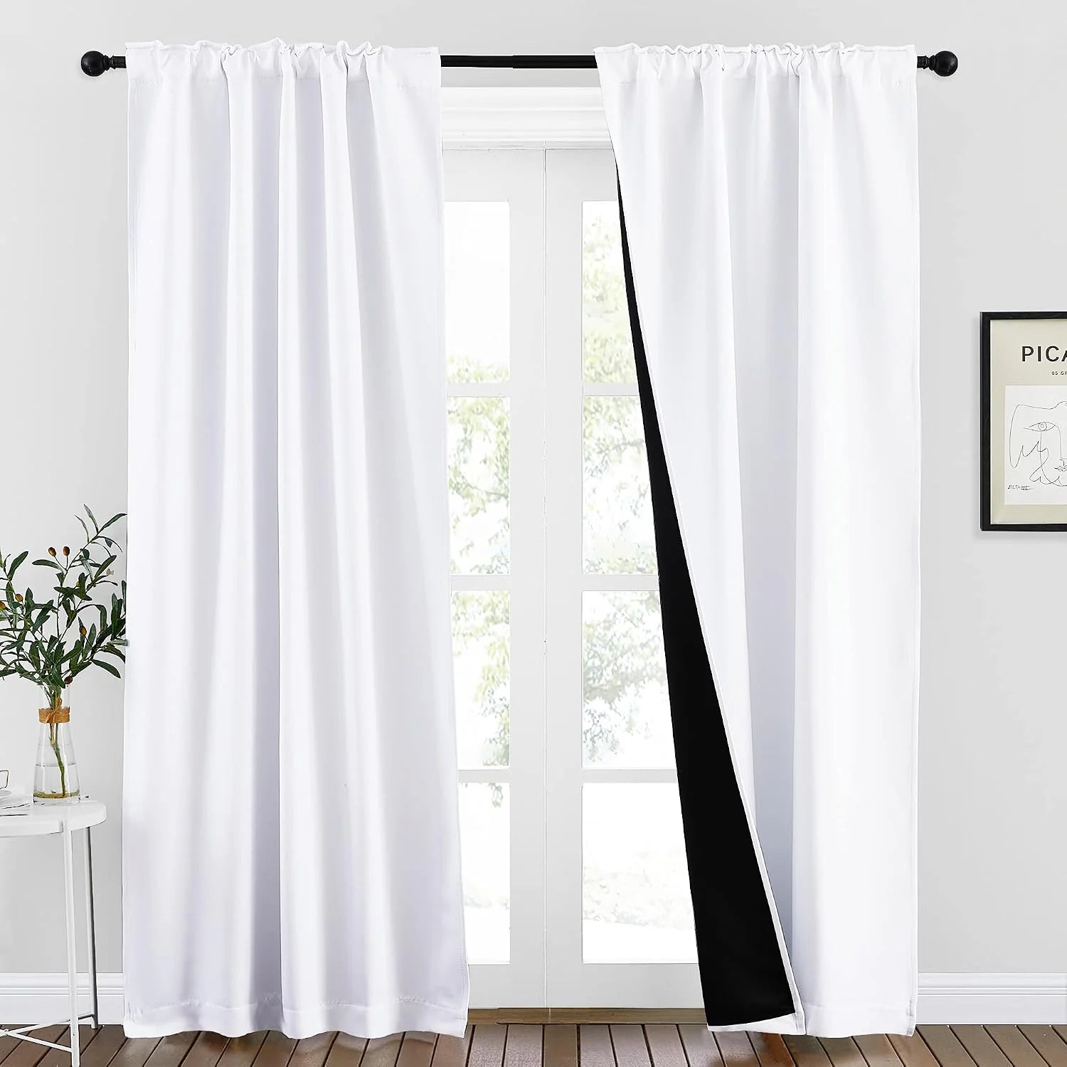 White rod-pocket blackout curtains with black lining on bright glass patio doors
