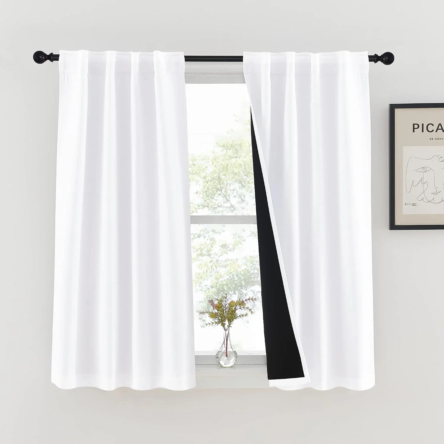 White rod pocket blackout curtains with black lining on a black curtain rod