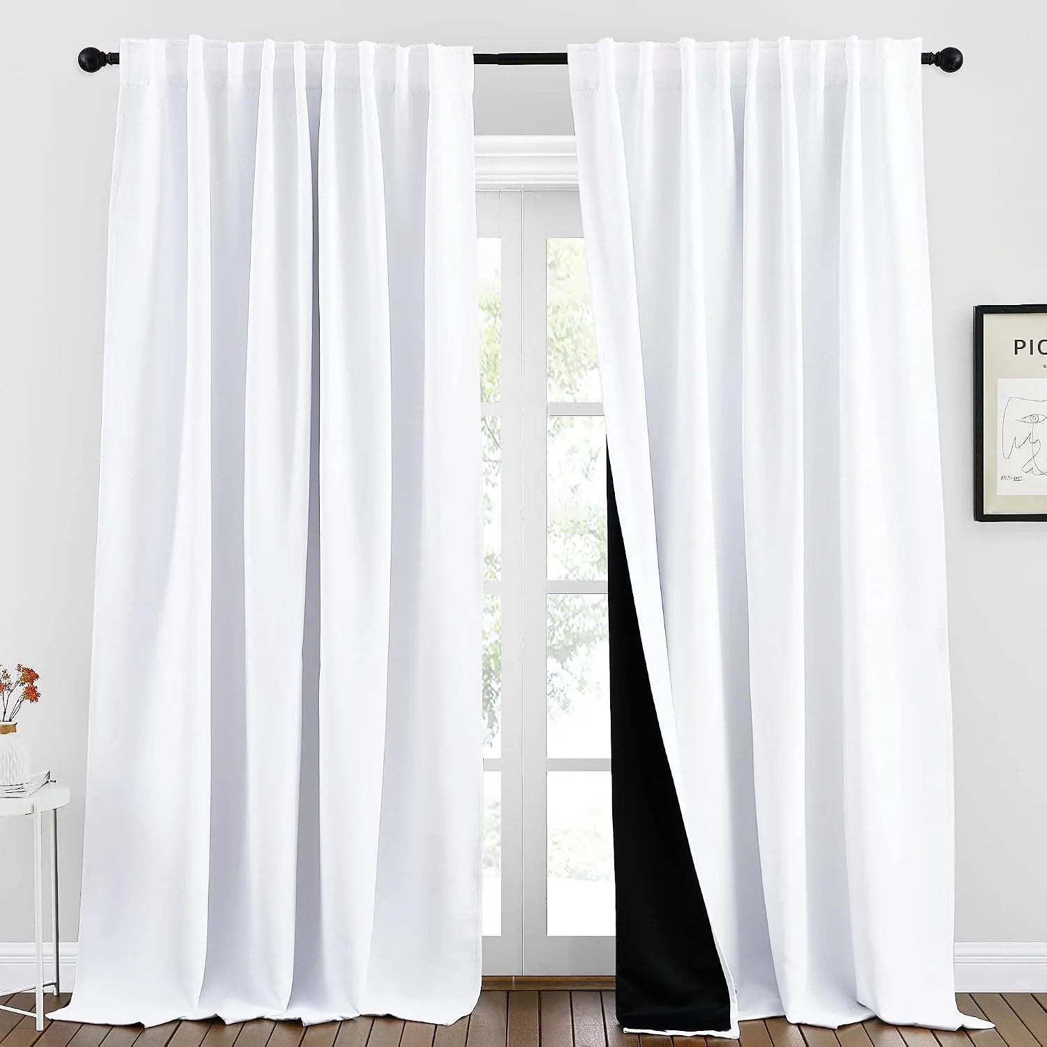 White blackout curtains with pleated top and black lining on a black rod
