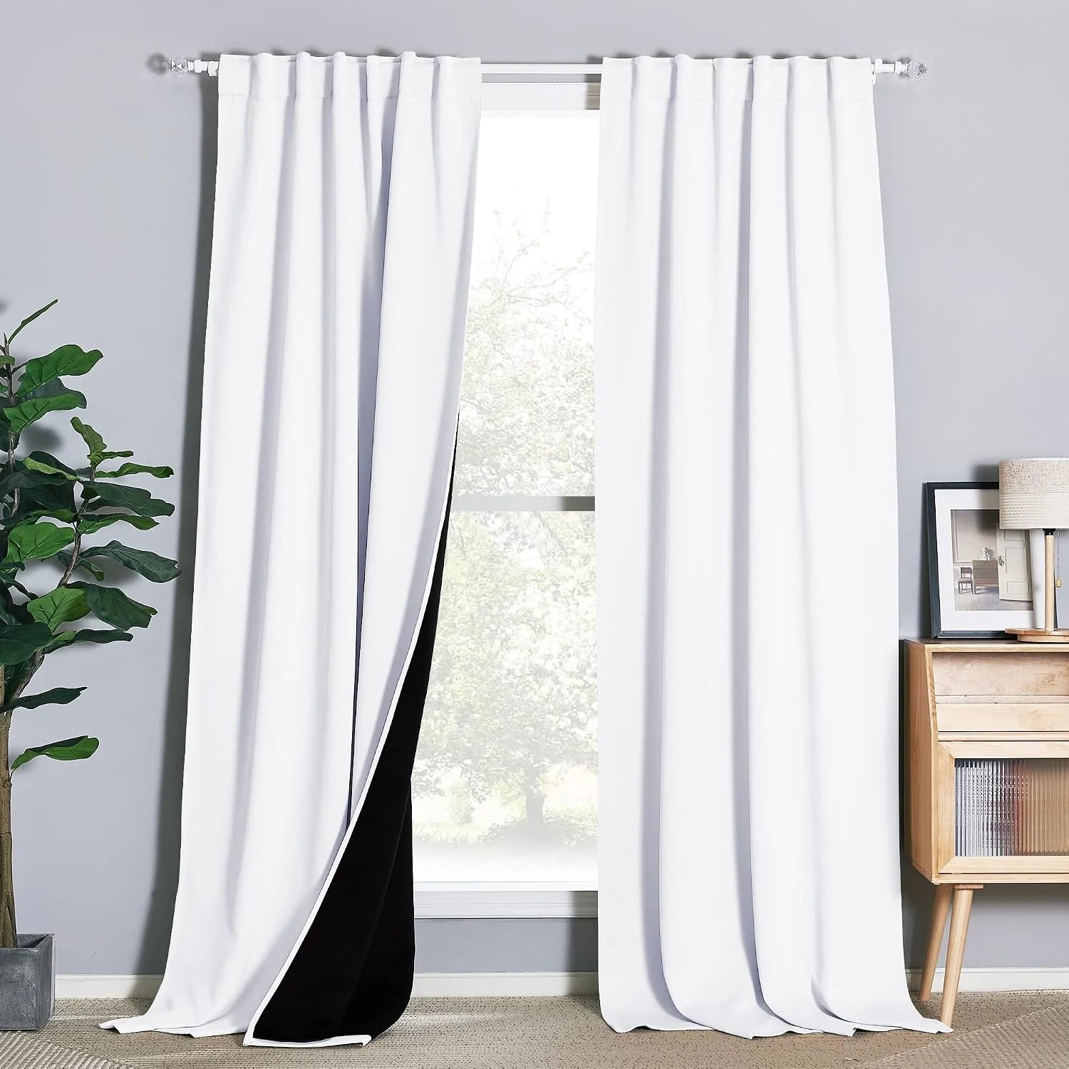 White blackout curtains with pleated header on a bright modern window in a gray room