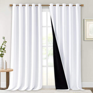White grommet blackout curtains on a wooden rod, with one partially open revealing its black lining.