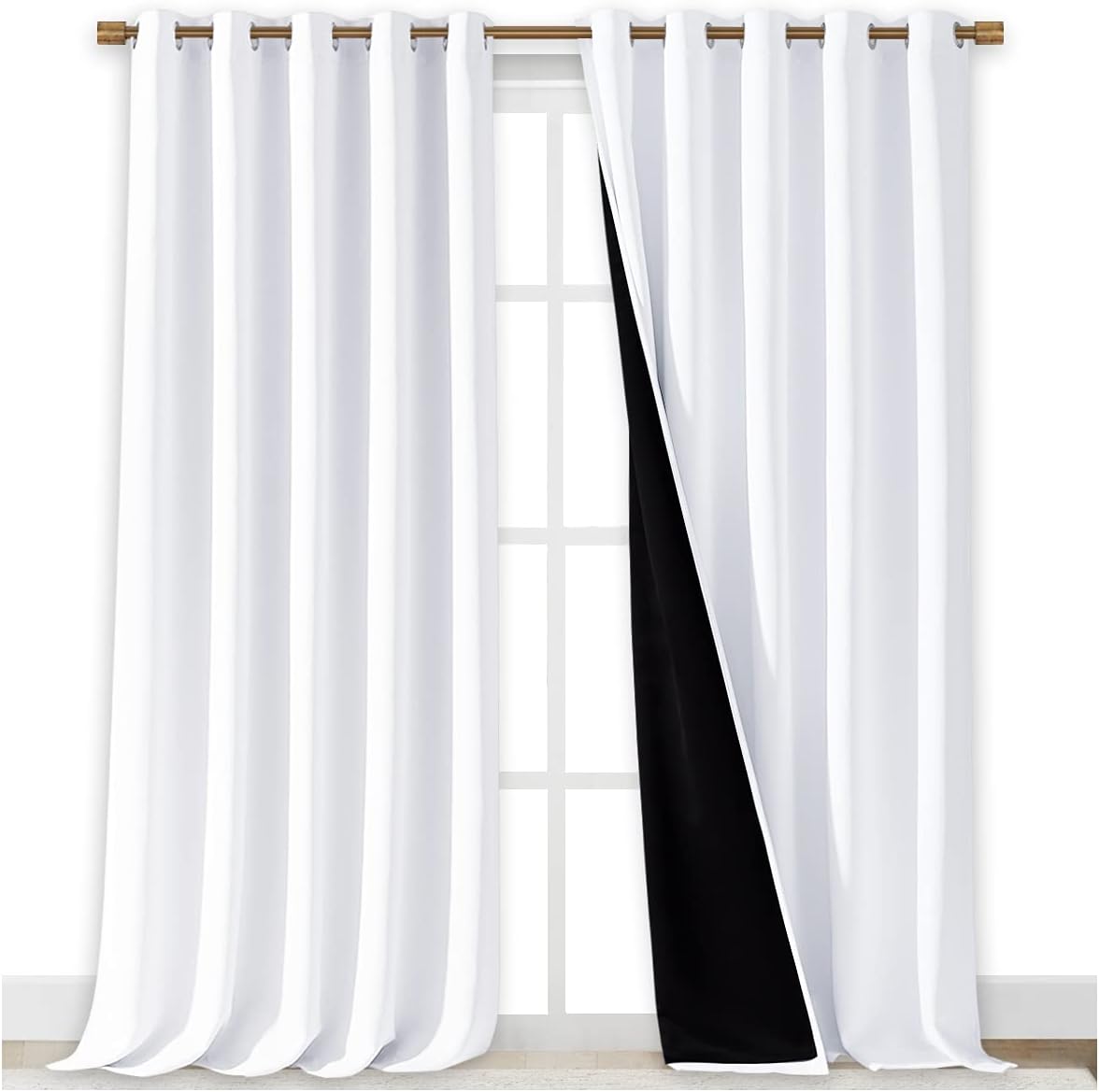 White blackout curtains with bronze grommet top hanging on a rod. Black lining is visible on the inner side of one panel.