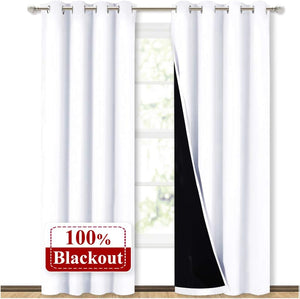 White blackout curtains with silver grommets, showing a thick black lining for total light blocking.