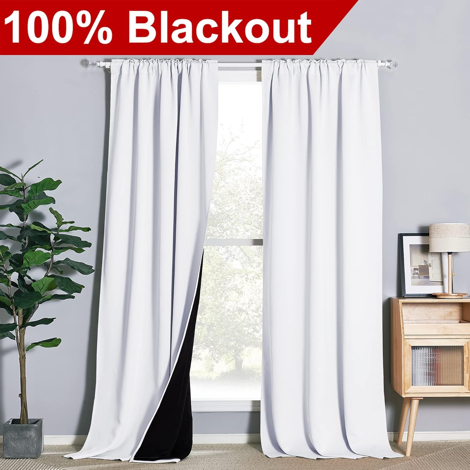 White blackout curtains with a gathered rod pocket top, showing black lining. Hanging on a window rod.