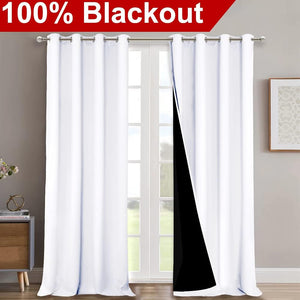 White grommet top blackout curtains with a visible black thermal lining hanging over a window.