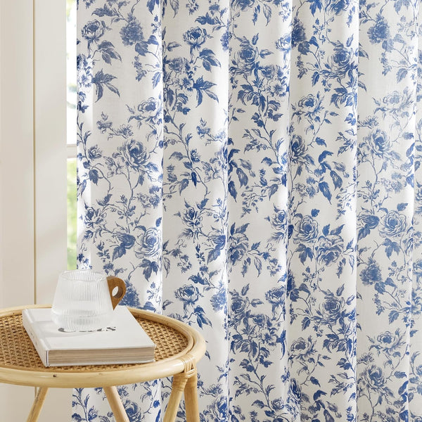 White linen blend curtains featuring a classic blue floral rose pattern, styled by a window.