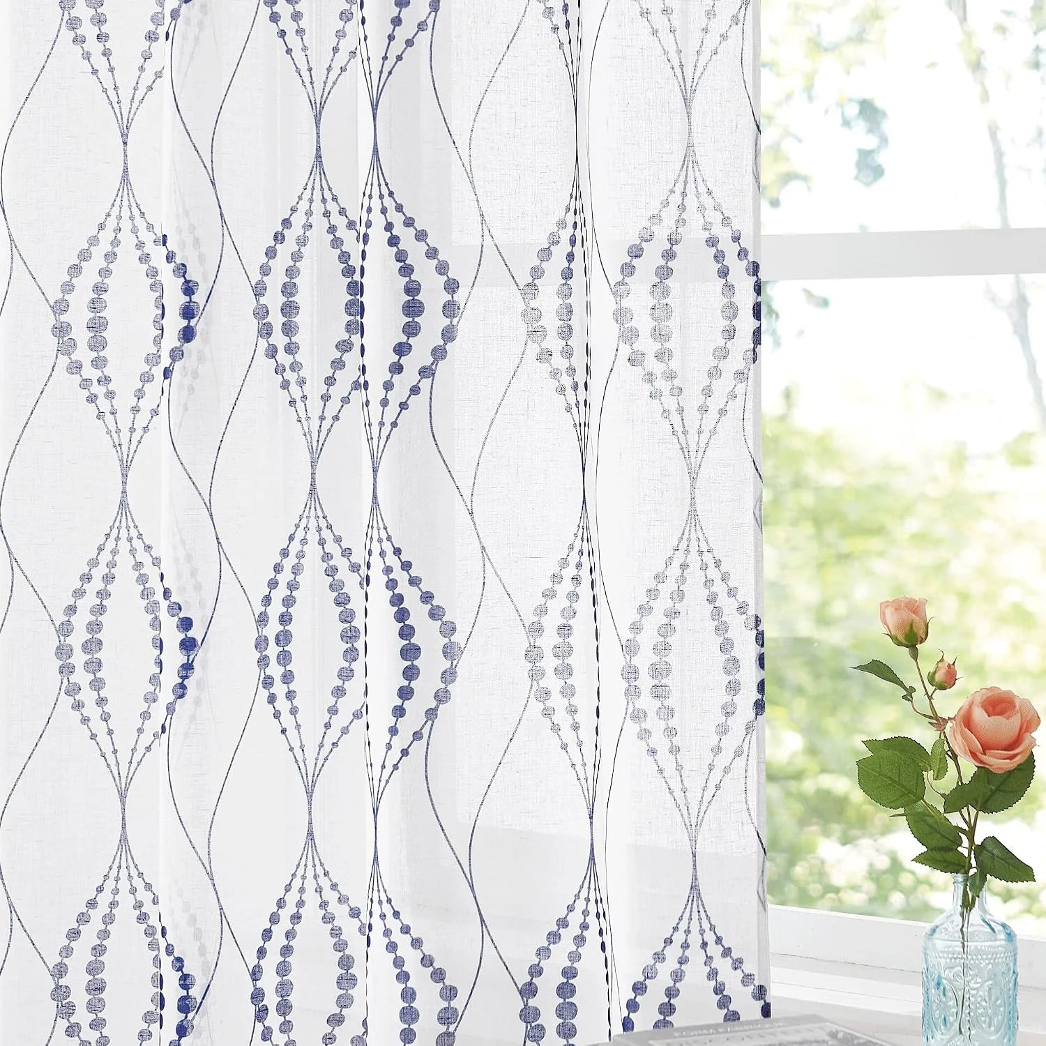 White sheer curtain with blue geometric dotted pattern by a bright window