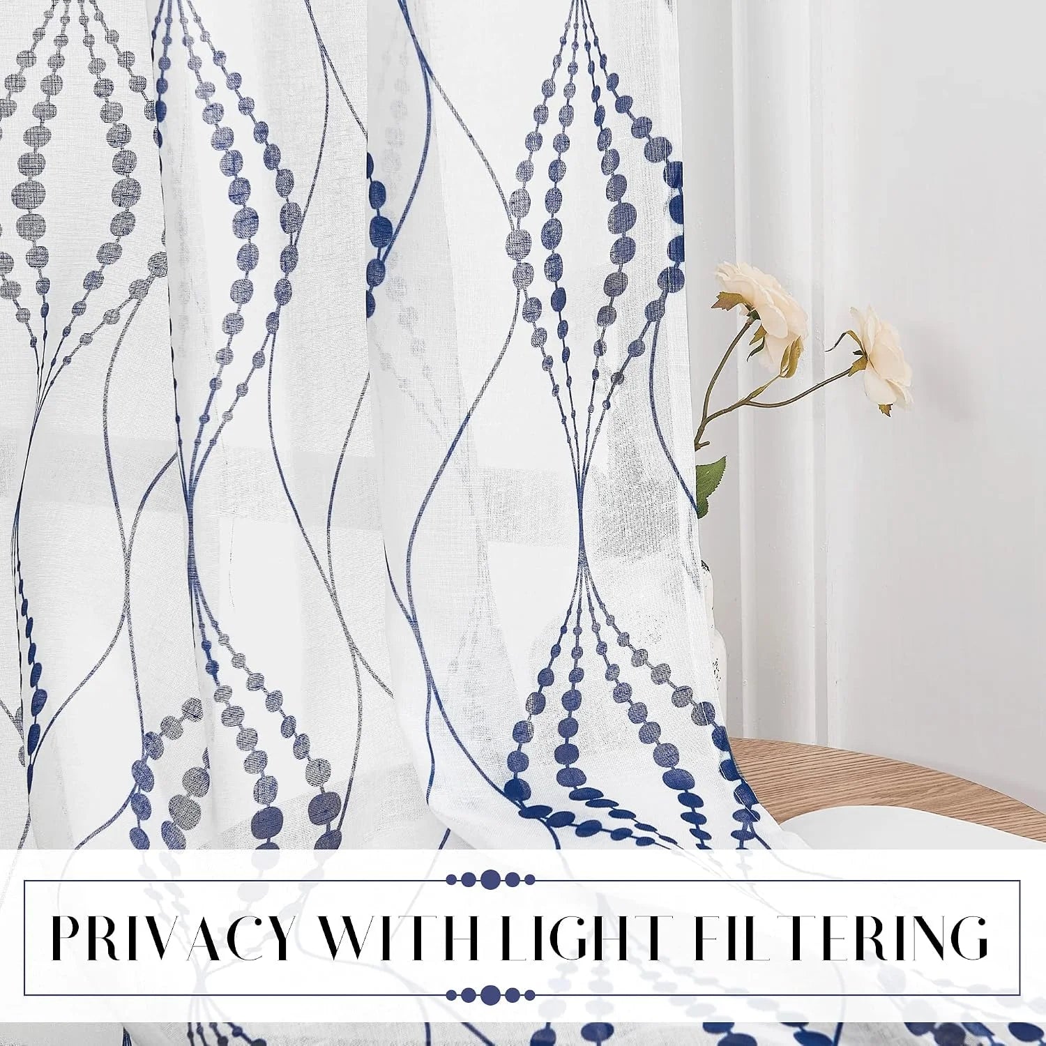 White sheer curtain with blue dotted leaf pattern filtering light by a window