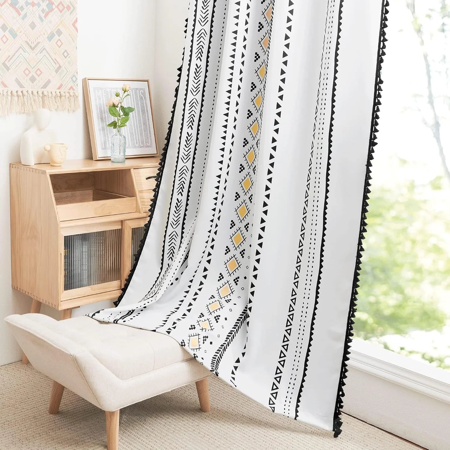 White boho curtain with black geometric print and tassel trim by bright window