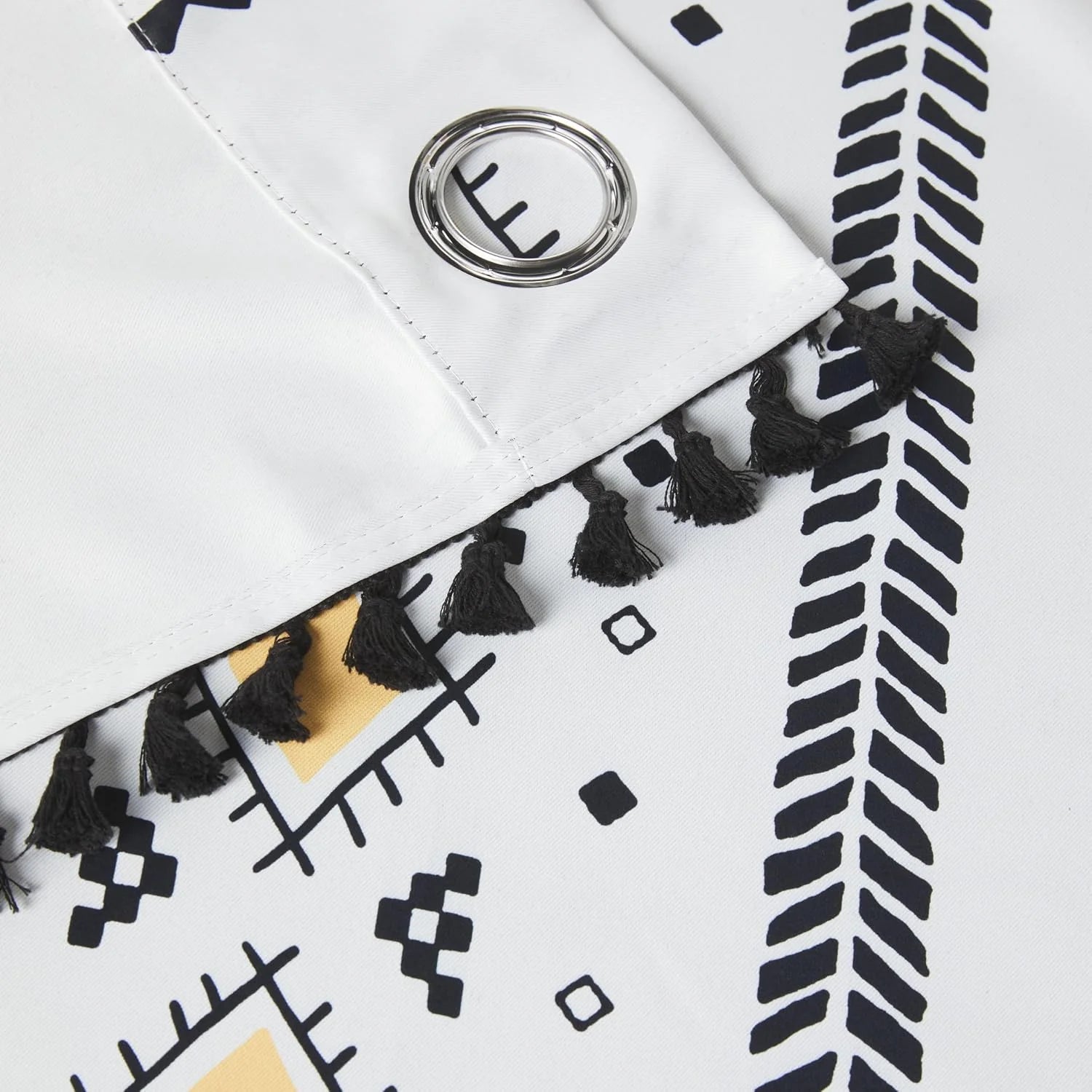 White boho shower curtain with black tassels, tribal print, and silver grommet