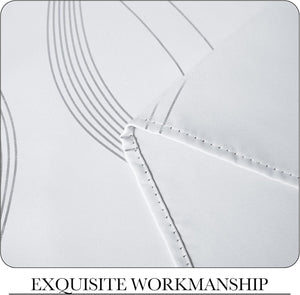 Close-up of white woven fabric with subtle grey wavy lines and neat stitching.